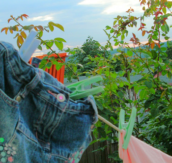 Washing on the line in the evening, pinned with angular, pastel pegs.